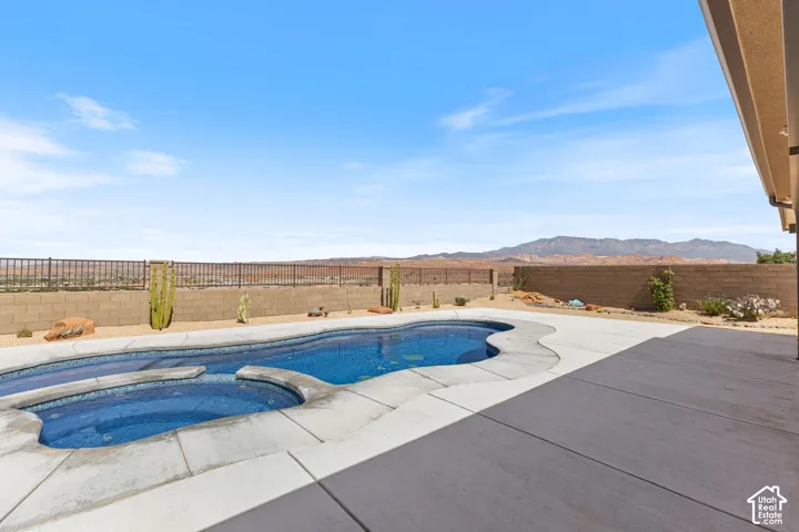 Curved inground pool with integrated spa, surrounded by expansive concrete decking