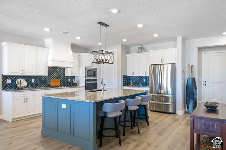 Expansive kitchen island featuring a granite countertop and paneled base