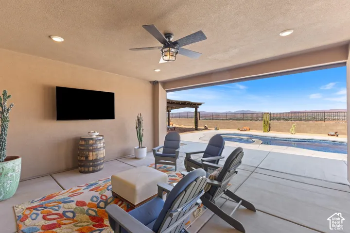 Covered patio featuring recessed lighting, a ceiling fan, and mounted outdoor television