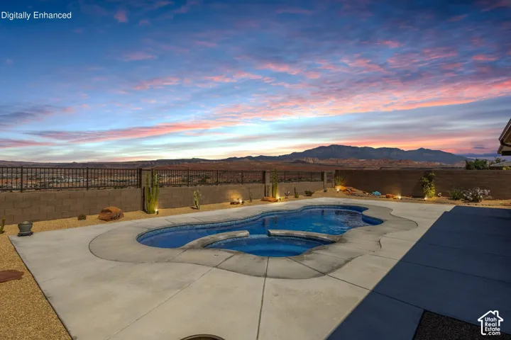 Freeform swimming pool and integrated spa with a concrete surround