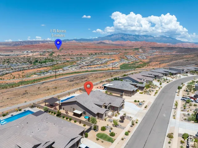 Aerial perspective showcasing a residential street with single-story homes and landscaped yards, with a mountain backdrop