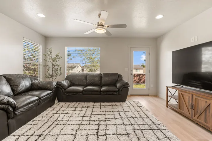 Spacious living area featuring light wood-finish flooring and recessed lighting