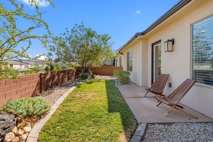 Expansive outdoor patio with direct access to interior spaces, featuring a stucco exterior and block wall fencing