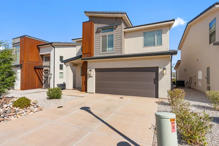 Contemporary-style residence featuring a stucco exterior with textured paneling and wood-finish accents