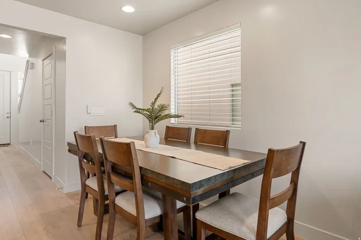 Bright dining area featuring light wood-finish flooring, recessed lighting, and a window with horizontal blinds