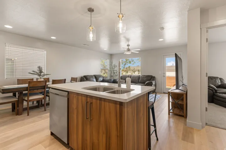 Kitchen island featuring wood-finish cabinetry, a light-toned countertop, and dual sinks