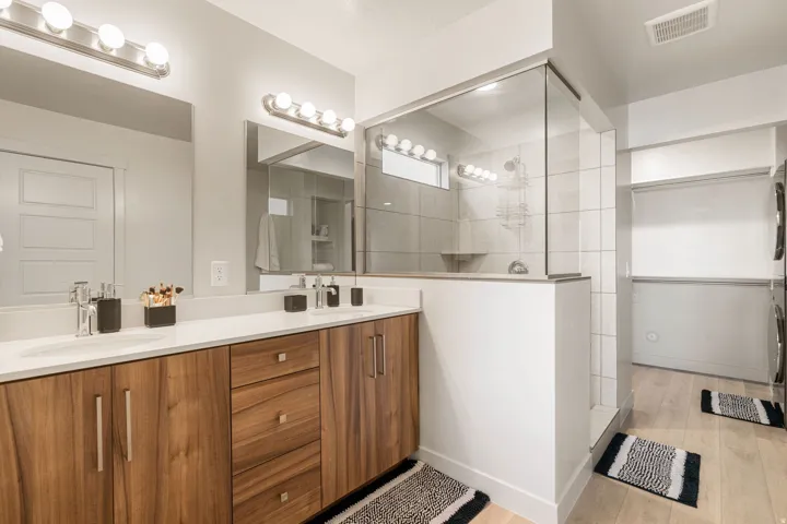 Double vanity featuring wood-finish cabinetry, white countertops, and undermount sinks