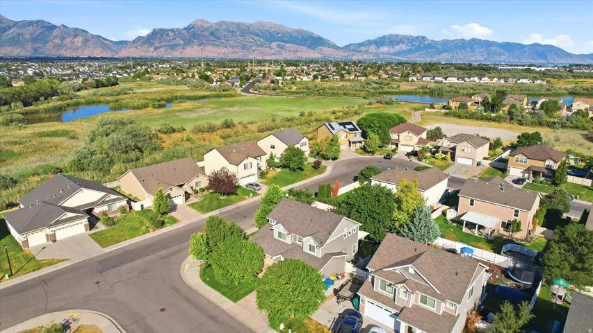 Residential neighborhood featuring varied architectural styles and mature landscaping, with distant mountains and water features