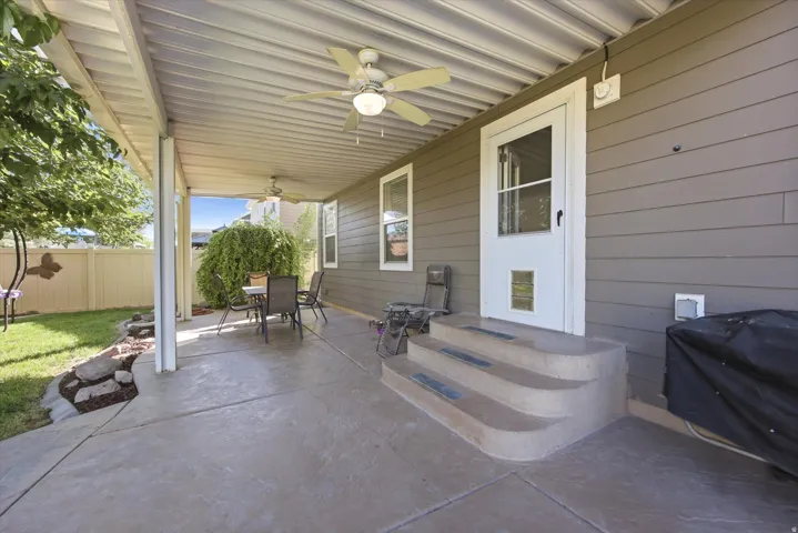 Covered patio with stamped concrete flooring, curved step detail, and ceiling fan
