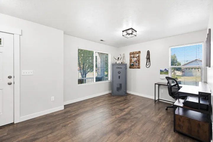 Spacious room featuring wood-finish flooring and light-toned walls