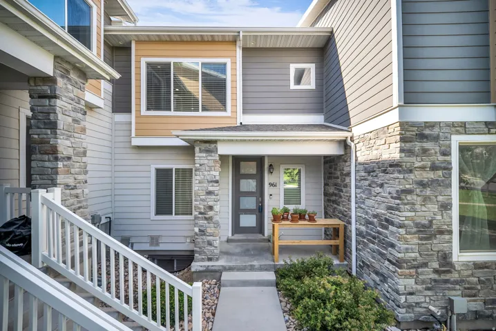 Contemporary multi-level facade featuring varied siding materials including light gray horizontal panels, darker gray horizontal panels, and tan horizontal panels