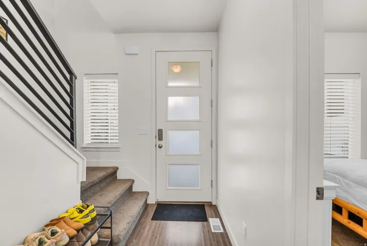 Entryway featuring a modern door with frosted glass panels and wood-finish flooring