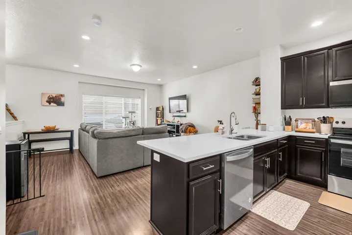 Open-concept living area featuring wood-finish flooring, recessed lighting, and a sliding glass door