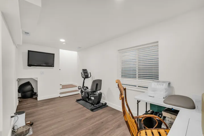 Lower level room featuring wood-finish flooring and recessed lighting