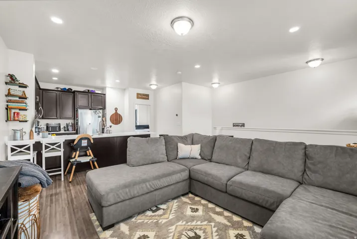 Open-concept living space featuring wood-finish flooring, recessed lighting, and a kitchen island with built-in cabinetry