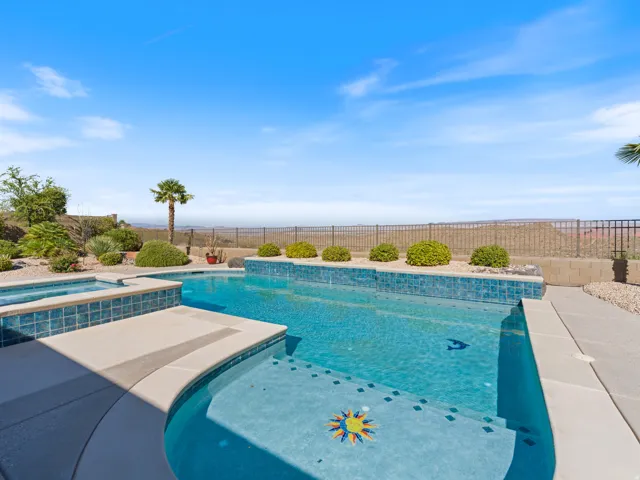 Outdoor swimming pool with integrated spa and decorative tile accents