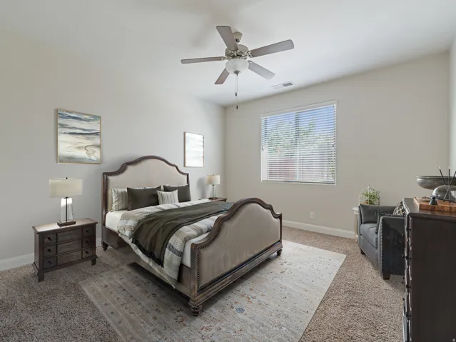Spacious room with plush carpeting, neutral wall tones, a ceiling fan fixture, and a large window with horizontal blinds