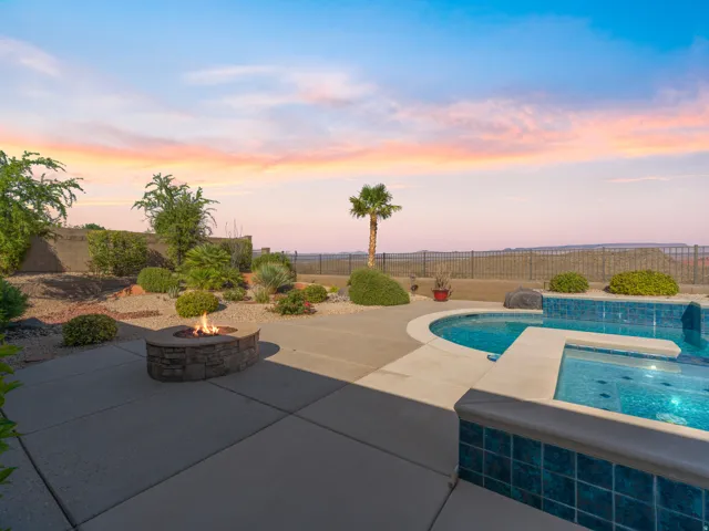 Concrete patio with an integrated swimming pool and spa, featuring blue mosaic tile detailing