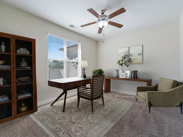 Bright room featuring neutral wall tones and a ceiling fan with integrated lighting