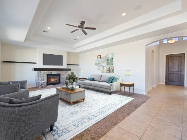 Living area with a stone fireplace, integrated mantel, and recessed lighting
