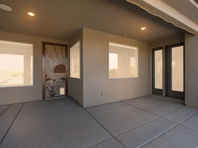 Covered patio with recessed lighting, textured concrete flooring, and multiple windows