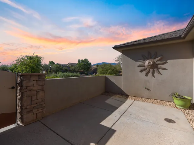 Private outdoor patio space featuring a concrete slab, decorative stone wall accents, and an exterior stucco finish