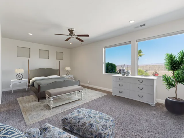 Spacious room featuring broad windows with exterior views, recessed lighting, and a ceiling fan