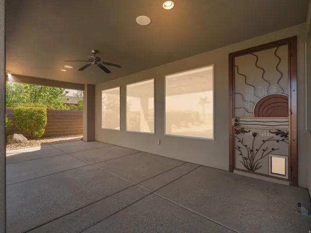 Covered patio featuring concrete flooring, a ceiling fan, recessed lighting, and a decorative security screen door with an integrated pet door