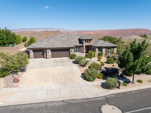 Single-story residence featuring a tile roof, a three-car garage, and a concrete driveway