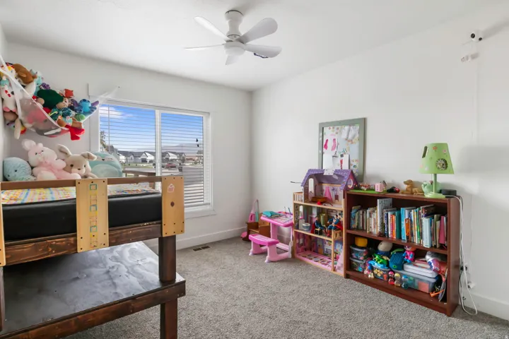Bright interior with a ceiling fan and a window with horizontal blinds
