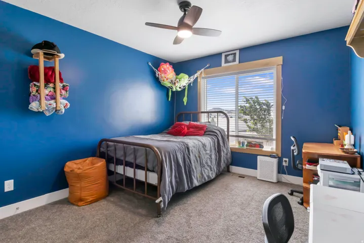 Carpeted flooring, a ceiling fan with integrated lighting, window with blinds, and painted walls