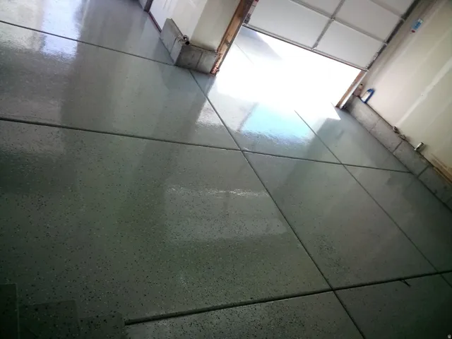 Finished concrete flooring with expansion joints and a speckled coating