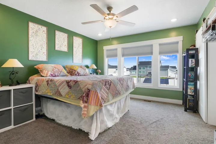 Recessed lighting, ceiling fan, expansive windows, green accent walls, and plush carpeting