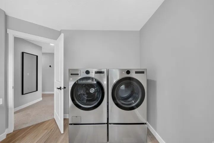 Dedicated laundry area featuring front-loading washer and dryer units on pedestals
