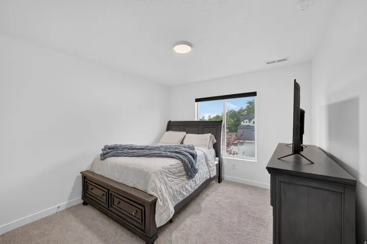 Carpeted bedroom featuring white walls, a recessed window, and a flush-mount ceiling light fixture