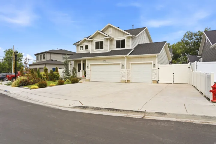 Contemporary two-story residence with light-toned siding and dark shingle roofing