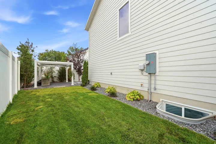 Expansive green lawn with a white privacy fence