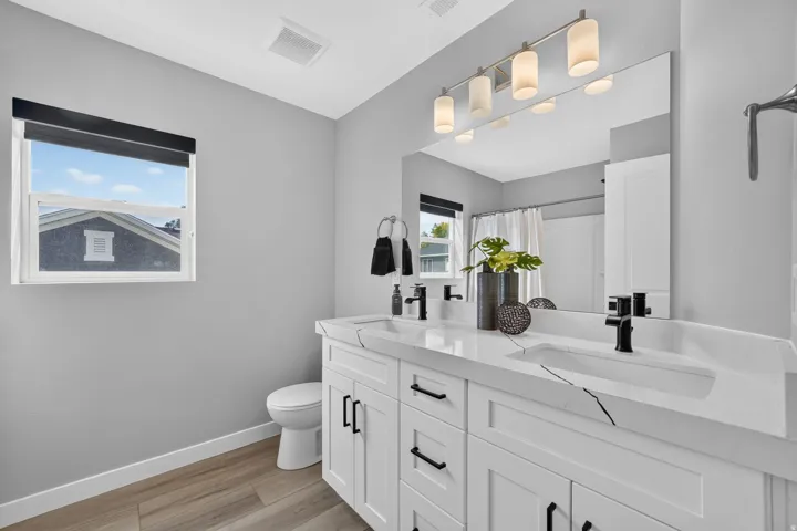 Dual vanity with integrated sinks, white cabinetry, and matte black fixtures