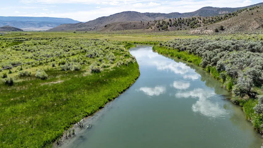 River frontage with lush green banks and distant rolling hills