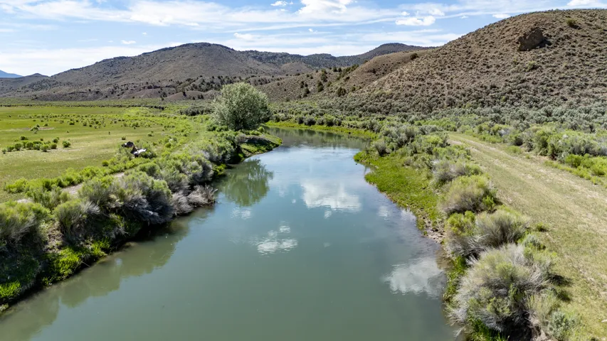 River frontage with surrounding natural landscape, including mature trees and rolling hills
