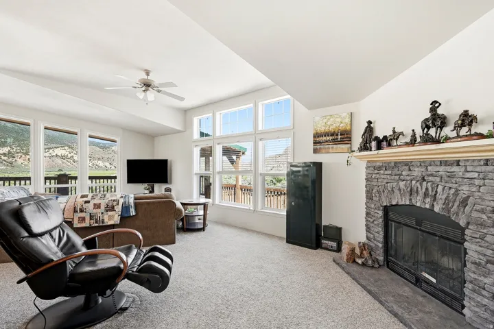 Living area with a stone fireplace, integrated fireplace insert, and stone hearth