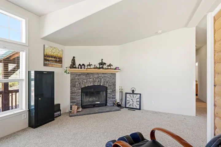 Corner stone fireplace with a wood mantle and stone hearth