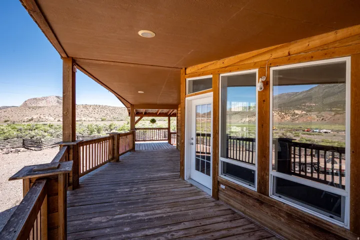 Expansive covered wood deck with a natural wood finish, featuring exposed wood beams and recessed lighting