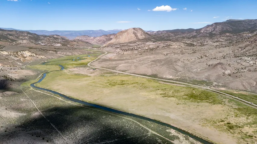 Expansive high-desert landscape featuring a winding river and mountainous terrain