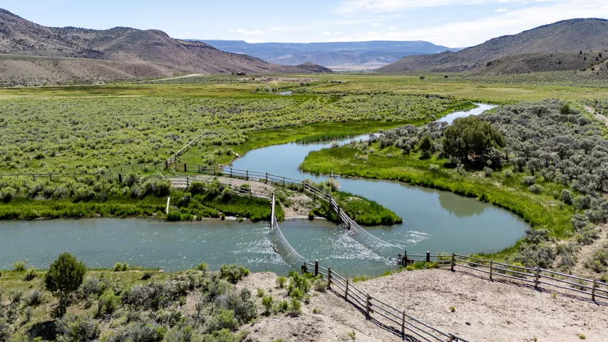 Winding river through expansive green fields and low hills