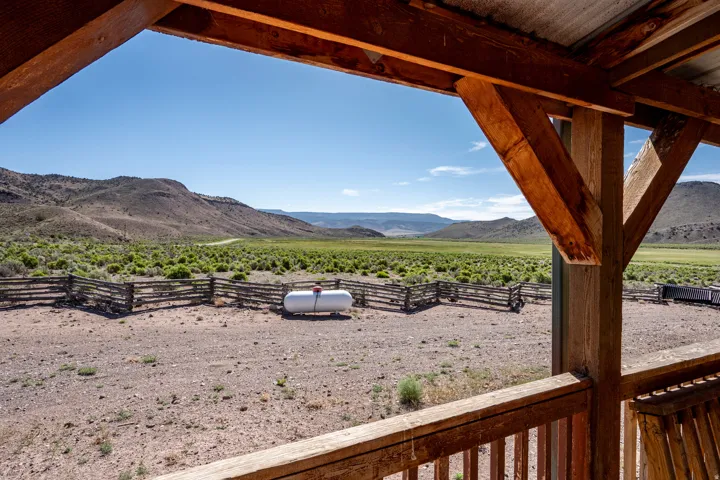 Expansive outdoor space featuring a propane tank, a wooden fence, and open terrain