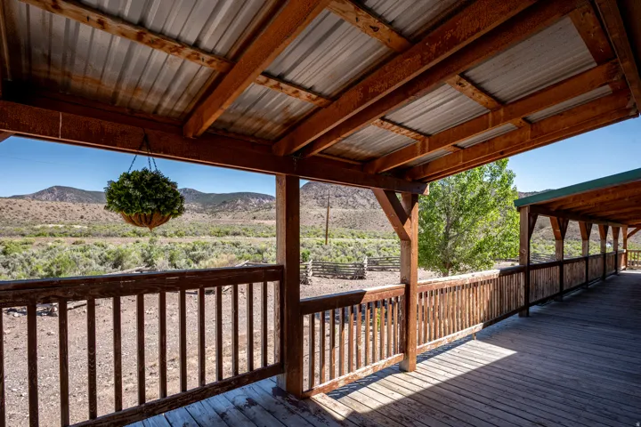 Expansive wood-finish deck with a corrugated metal overhang, wood-finish railings, and structural wood beams