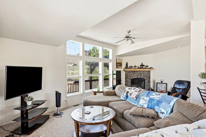 Living area with a stone fireplace, recessed hearth, and wood mantel