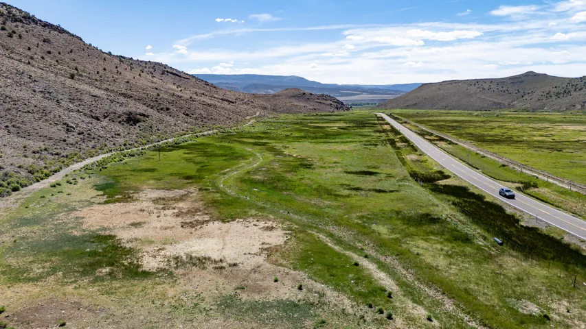 Expansive natural landscape featuring rolling hills and a paved roadway