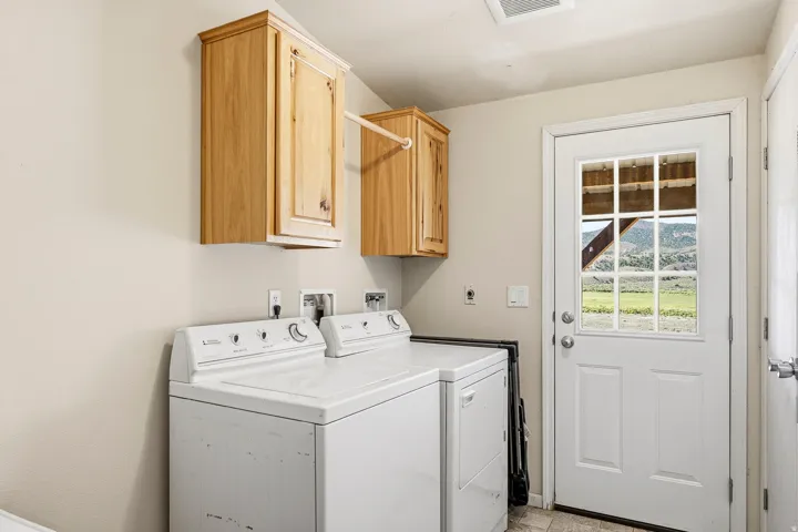 Functional utility space with overhead cabinetry and a glass-paneled exterior door